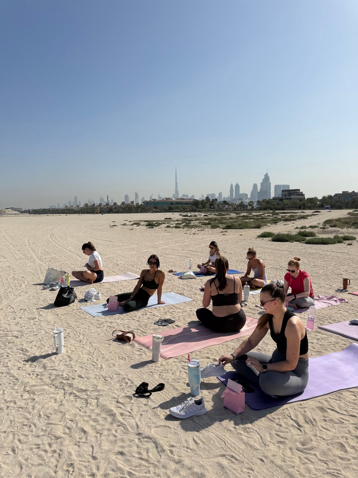 The International Women's Day class seated together with pink gift bags, Dubai skyline behind